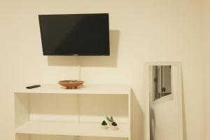 巴拉那的住宿－Apart ciudad de Parana, Entre Rios，白色架子上的电视机,上面放着碗