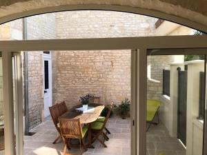 an extension to a patio with a table and chairs at LOGIS DU FAUBOURG petite maison de charme, tranquille, calme et lumineuse in Val-de-Mercy