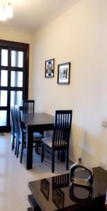 une salle à manger avec une table et des chaises noires dans l'établissement Sporting Panorama Apartment(Families Only), à Alexandrie