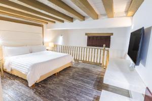 Un pat sau paturi într-o cameră la GHL Collection Armería Real Hotel