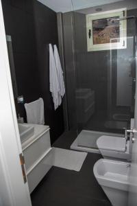een badkamer met een wastafel, een toilet en een douche bij Casa La Picota in Los Llanillos