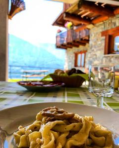 a plate of pasta on a table in a restaurant at Agriturismo Cavria in Castione Andevenno