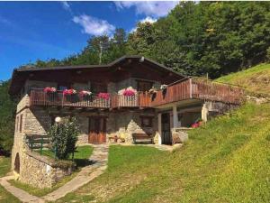 a house with a balcony on top of a hill at Agriturismo Cavria in Castione Andevenno