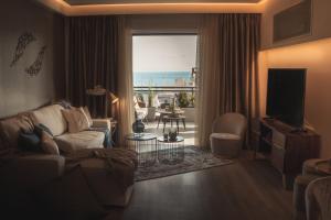 a living room with a couch and a television at Sea view super romantic apartment in Athens