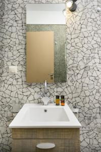 Un baño con un lavabo blanco y un espejo. en Villa Lunea, en Kalamaki