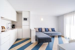 a living room with two chairs and a kitchen at Apartamentos Sunway Amapola in Sitges