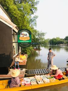 佛丕的住宿－Baan Bon Resort Bang Tabun，一群人乘着一条河上的小船