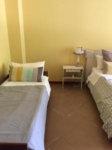 ミラノにあるAppartamento San Siroのベッド2台、テーブル(ランプ付)が備わる客室です。