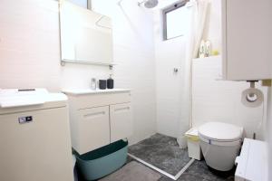 a white bathroom with a sink and a toilet at Modern Home In The Heart of Nachlaot in Jerusalem