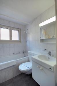 een witte badkamer met een toilet en een wastafel bij PABS Résidences - Kronenstrasse 37 (36) in Zürich