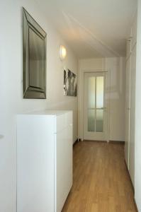 een witte kamer met een spiegel en een deur bij PABS Résidences - Kronenstrasse 37 (36) in Zürich