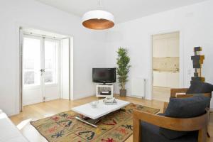 リスボンにあるChiado Design Apartment 5Eのテーブルとテレビのあるリビングルーム
