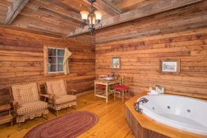 a bathroom with a tub and a table and chairs at 7F Lodge and Events in College Station +37 photos