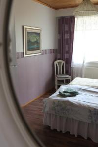 a bedroom with a bed and a window and a chair at Arctic Circle Apartment in Rovaniemi
