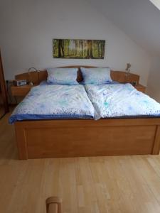 un letto con un piumone blu e due cuscini di Ferienwohnung mit Aussicht a Eberbach