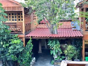 un edificio con techo rojo con árboles y plantas en Cabañas La Finca, en Atlixco