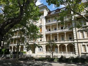 a large white building with trees in front of it at Spazioso e accogliente nel centro di Merano in Merano