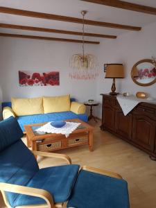 un soggiorno con divano blu e tavolo di Ferienwohnung mit Aussicht a Eberbach