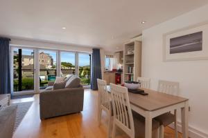 una cucina e un soggiorno con tavolo e divano di The Beach House & Porth Sands Apartments a Newquay