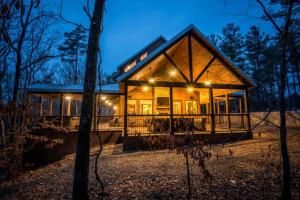 a house in the woods at night with lights at Indian Springs Lodge-Game Room, Video Game Table in Stephens Gap