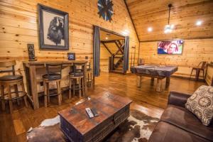 a living room with a table and a bar in a cabin at Indian Springs Lodge-Game Room, Video Game Table in Stephens Gap