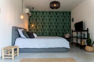a bedroom with a white bed and a green wall at L'Oasis Vendargues in Vendargues