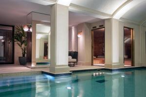 a swimming pool in a house with columns and a room at Les Jardins du Faubourg Hotel & Spa by Shiseido in Paris