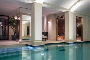 a swimming pool in a house with columns and a room at Les Jardins du Faubourg Hotel & Spa by Shiseido in Paris