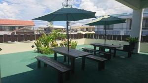 dwa stoły piknikowe i parasol na patio w obiekcie Miyakojima - house / Vacation STAY 270 w mieście Miyako-jima