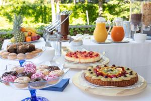 - une table avec des gâteaux, des tartes et d'autres desserts dans l'établissement Hotel Villa Aspe, à Bibione