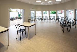 a room with tables and chairs in a room with windows at Hôtel Acadia in Lourdes