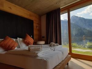 a bedroom with a large bed with a large window at Agriturismo Bio Ca' Pianazòla in Chiavenna
