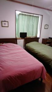 a bedroom with two beds and a window with a laptop at Miyakojima - house / Vacation STAY 270 in Miyako Island