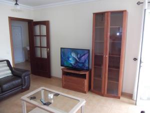 sala de estar con TV, sofá y mesa en Casa Katrina, en Tías