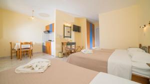a hotel room with two beds and a table at Aneton in Chrysi Ammoudia