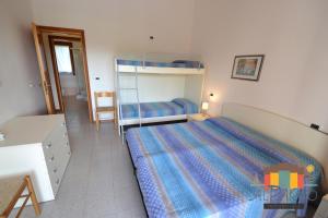 a bedroom with a bed and a bunk bed at Fiordo Topazio in Isola Albarella +23 photos