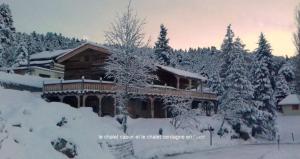 une maison recouverte de neige devant les arbres dans l'établissement Ker Capcir, à Bolquère-Pyrénées 2000