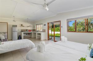 a bedroom with two beds and a kitchen at Eastbrook River Self Catering Cottages in Sedgefield