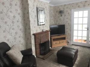 een woonkamer met een open haard en een televisie bij Seacroft in Kingsdown