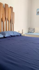 - une chambre avec un lit doté de draps bleus et de chaises en bois dans l'établissement SUD 47, à Molfetta