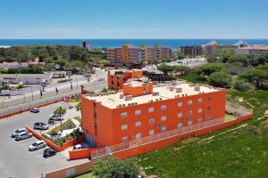 an orange building in front of a parking lot at Zodiaco in Quarteira