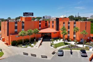 an orange building with cars parked in a parking lot at Zodiaco in Quarteira