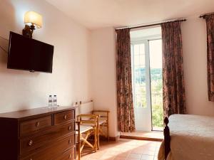 a bedroom with a dresser and a large window at Hotel Casa do Parque in Castelo de Vide