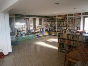 une bibliothèque avec de nombreuses étagères de livres dans l'établissement Casa de la Playa en Torredembarra, à Creixell