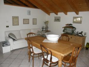 sala de estar con mesa de madera y sillas en La Casa Del Gelsomino, en Ospedaletto