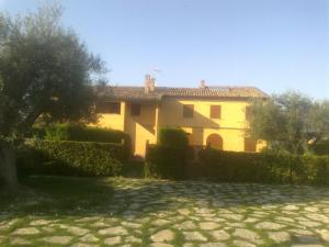a large yellow house with a hedge in front of it at IMMERSA NEL VERDE 2 in Osimo