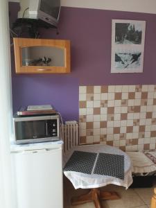 a small kitchen with a table and a microwave at Oceania Mielno in Mielno