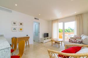 ein Wohnzimmer mit einem Sofa und einem Tisch in der Unterkunft Apartamentos DIANA Alcudia in Alcúdia