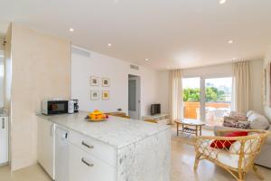 eine Küche mit einer Theke und ein Wohnzimmer in der Unterkunft Apartamentos DIANA Alcudia in Alcúdia