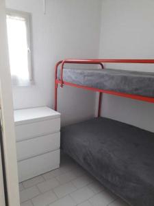ein Schlafzimmer mit einem Etagenbett und einem Fenster in der Unterkunft Studio cabine climatisé avec parking au Couchant in La Grande-Motte